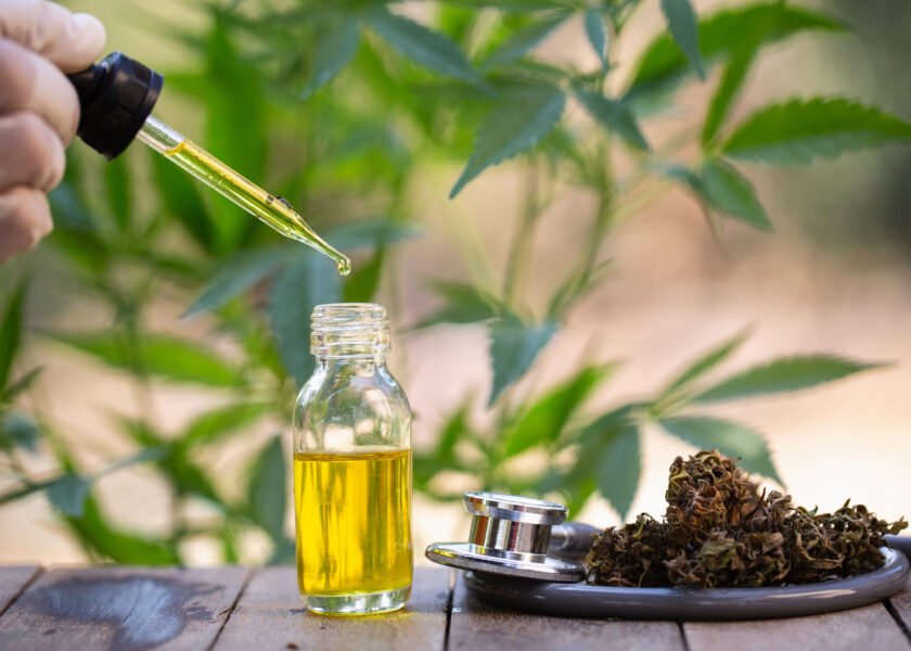 Hemp oil, Medical marijuana products including cannabis leaf, dried bud, cbd  and hash oil over black wood background